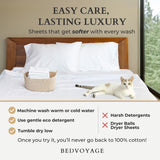 Bed with white bamboo sheets, cat, and text about easy care and lasting luxury bedding from Bedvoyage.