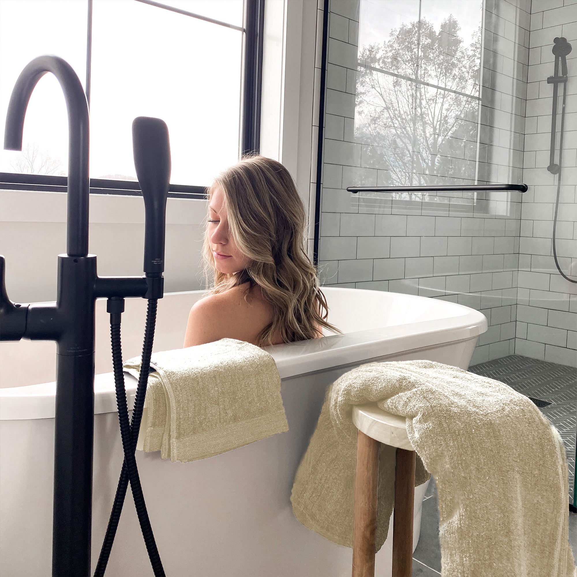woman in tub with sand beige melange bamboo bath sheet and hand towels near her