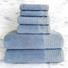 A set of ocean blue colored bamboo spa towels neatly stacked, including bath towels, hand towels, and washcloths.