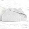 white folded bamboo bath towel sitting on a marble countertop