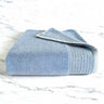 ocean blue folded bamboo bath towel sitting on a marble countertop