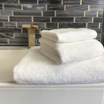 3 piece white bamboo towel set stacked on a bathroom counter