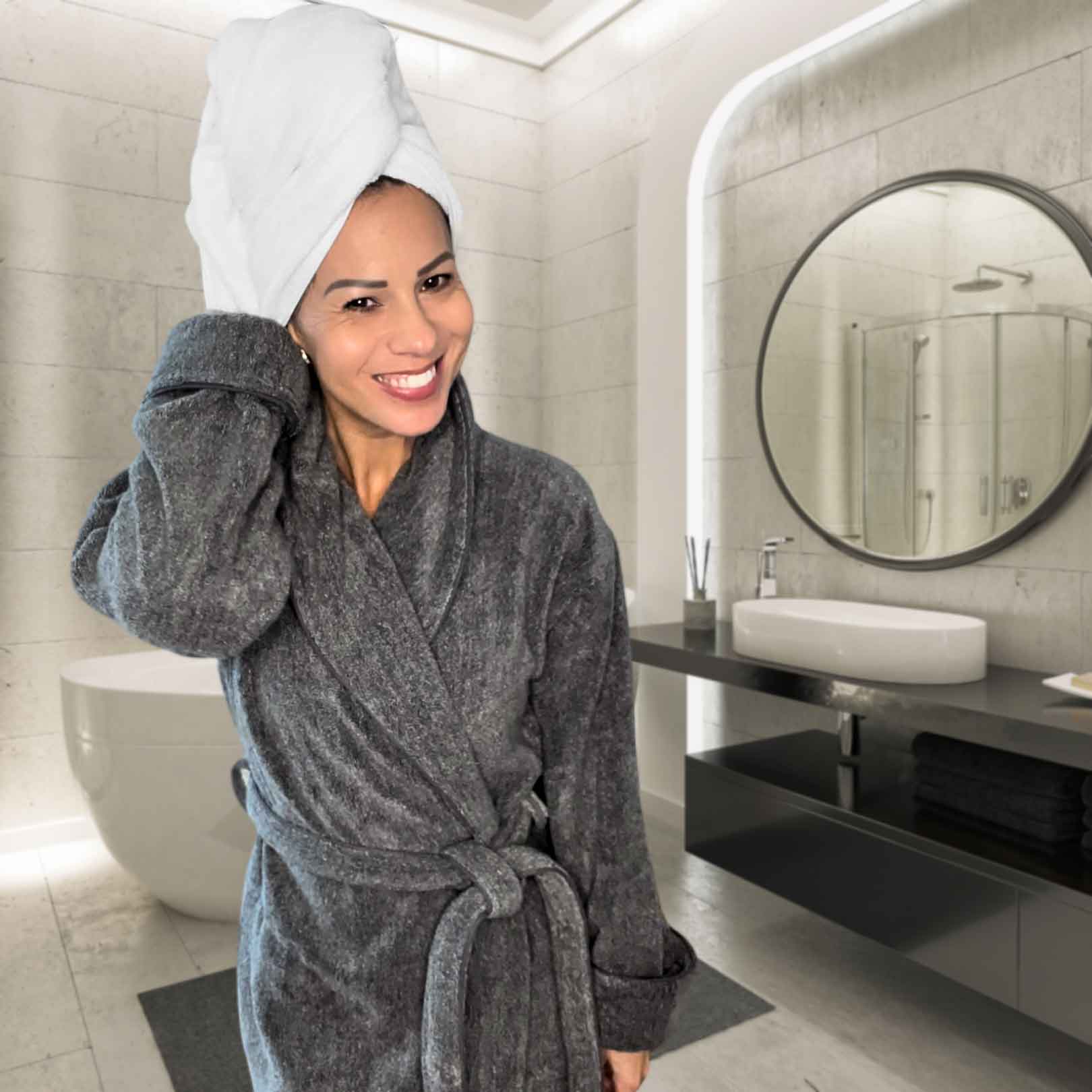 woman in charcoal bamboo robe with towel wrapped around hair standing in bathroom