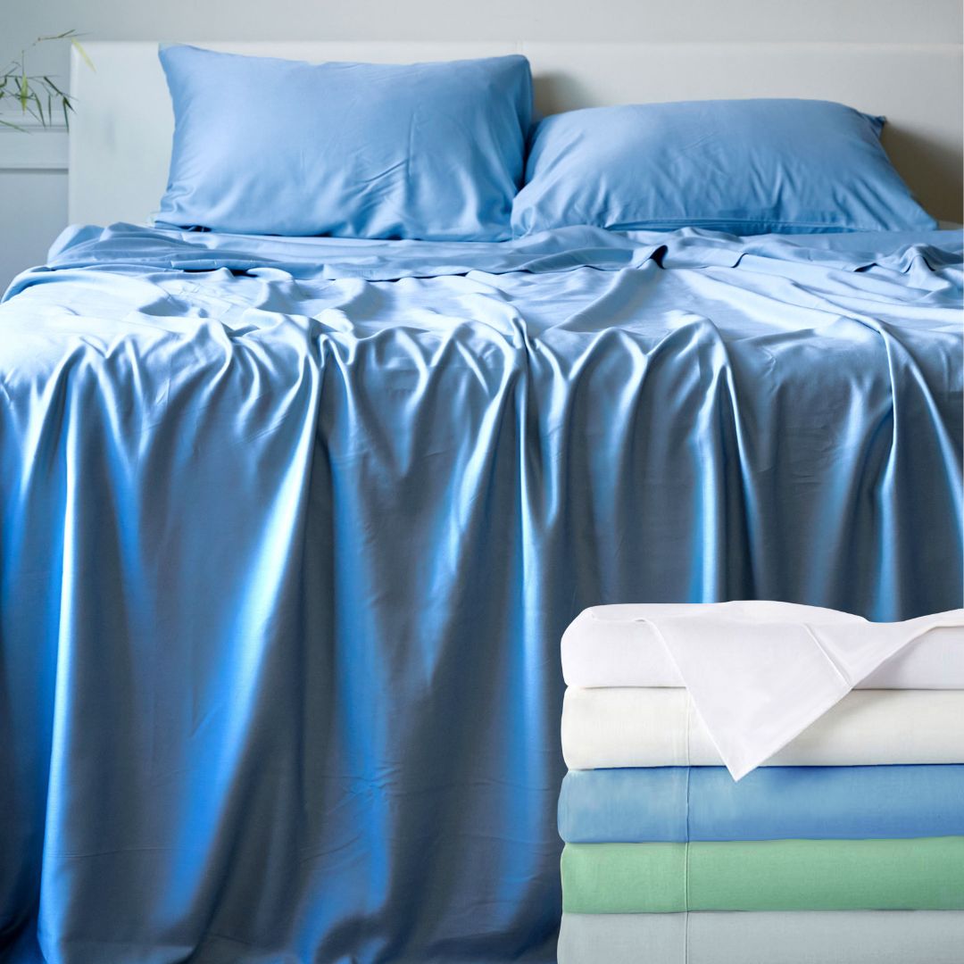 Blue bamboo bedding set with pillows and a folded blanket on a bed.