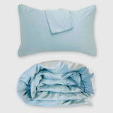 light blue sky bamboo duvet cover rolled up with floating pillow above it